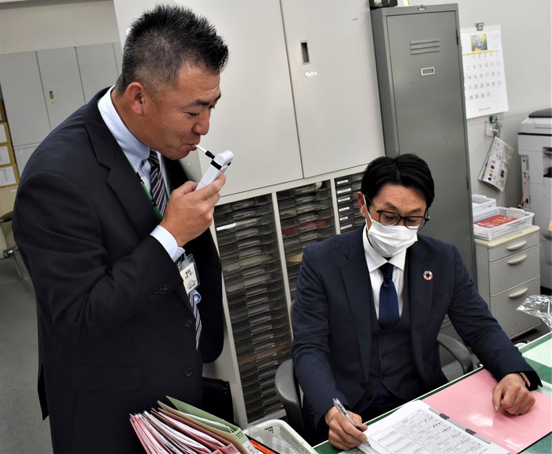 帰社時のアルコール検査を行う千葉信用金庫の職員。係長以上が立ち会い、結果を記録する=25日、千葉市中央区