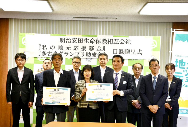 細井支社長（前列右から２人目）から目録を受け取った平山町長（中央）と飯田会長＝多古町役場