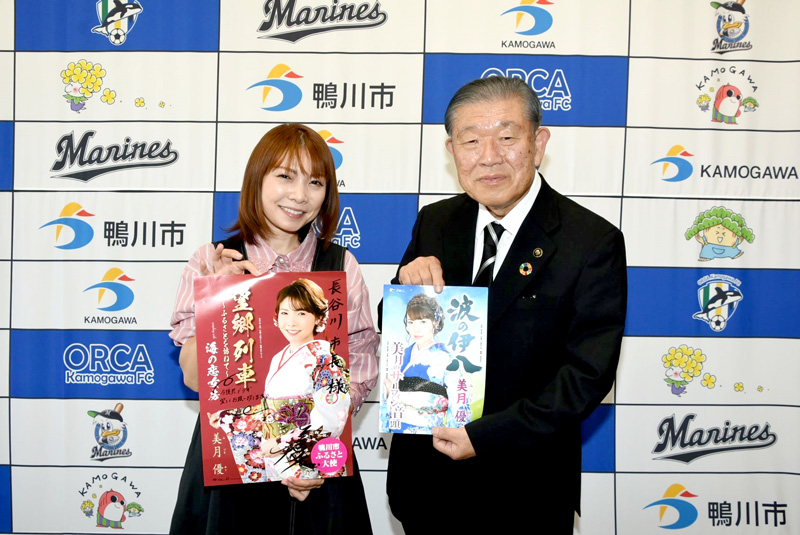 長谷川市長（右）に「望郷列車～ふるさとを訪ねて～」のポスターを手渡した美月さん（鴨川市提供）