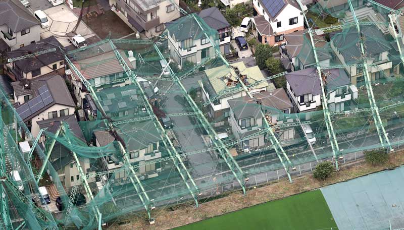 台風15号の影響でネットごと倒壊したゴルフ練習場のポール。住宅を直撃した=2019年9月9日午前、市原市(共同通信社ヘリから)