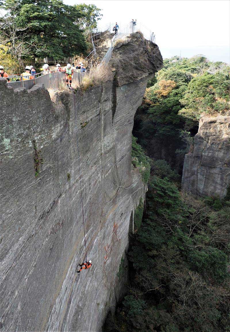 「地獄のぞき」横の絶壁約６０メートルを降下する救助隊員＝富津市、鋸南町