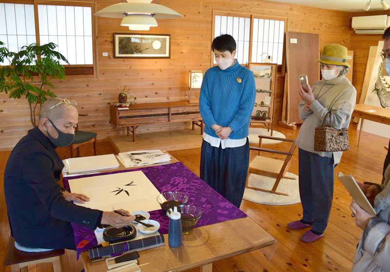 来場者の前で水墨画を描く河村さん