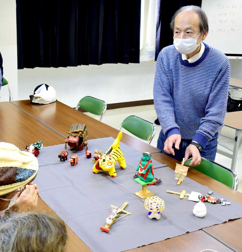 全国各地の郷土玩具を並べ、特徴を説明する久野さん＝睦沢町