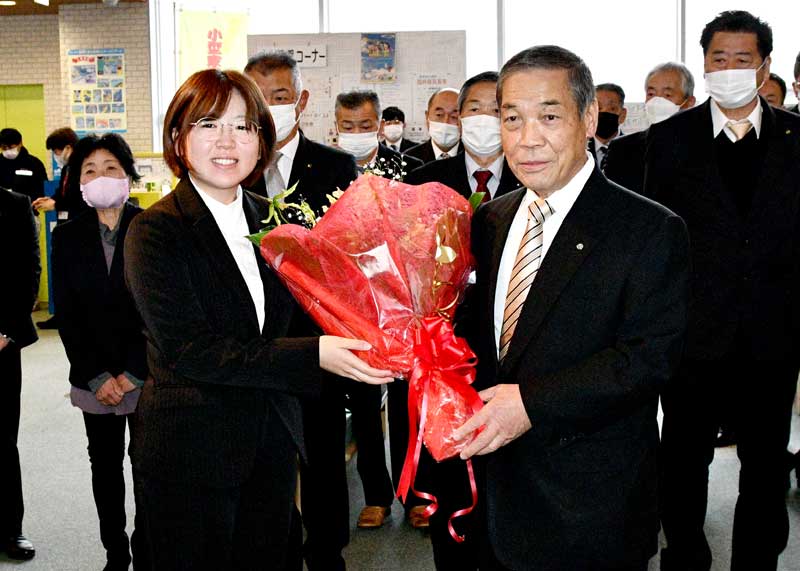職員から花束を受け取る岩田町長（右）＝２３日、東庄町役場