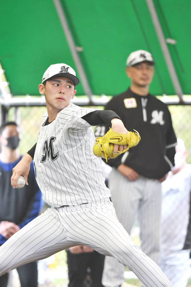 ブルペンで投げ込む千葉ロッテの佐々木朗。奥は吉井監督=2日、沖縄県石垣市