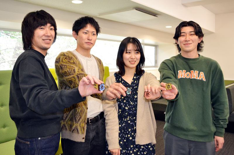 金やコバルトなどを表現したチョコを食べた学生ら=14日、千葉市稲毛区の千葉大学西千葉キャンパス