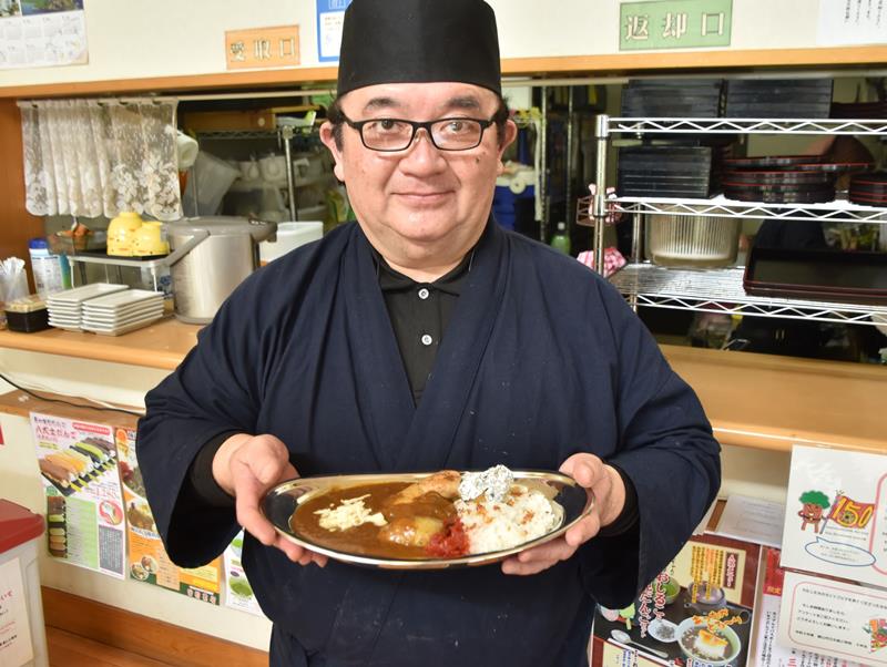たてやま海自カレーを手に持つ「里見茶屋」の西郷さん＝館山市