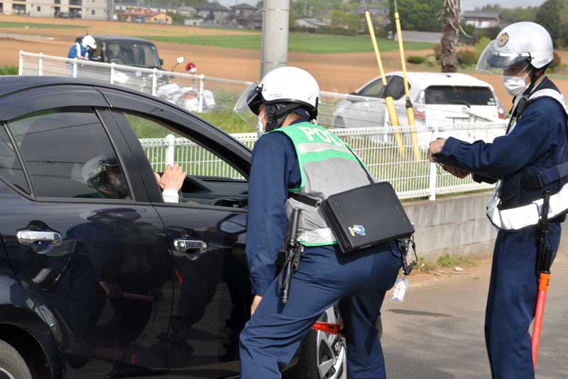 通行禁止違反者に事情を聴く佐倉署員=14日午前8時10分ごろ、八街市