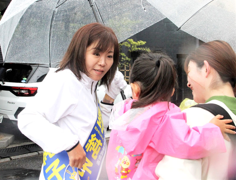 聴衆の親子と交流する岡野氏＝１５日、市川市のスーパー前