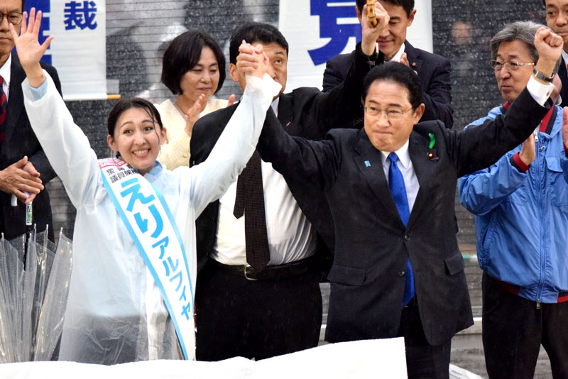 英利氏（左）と両手を高く上げ、聴衆にアピールする岸田首相＝１５日、新浦安駅前