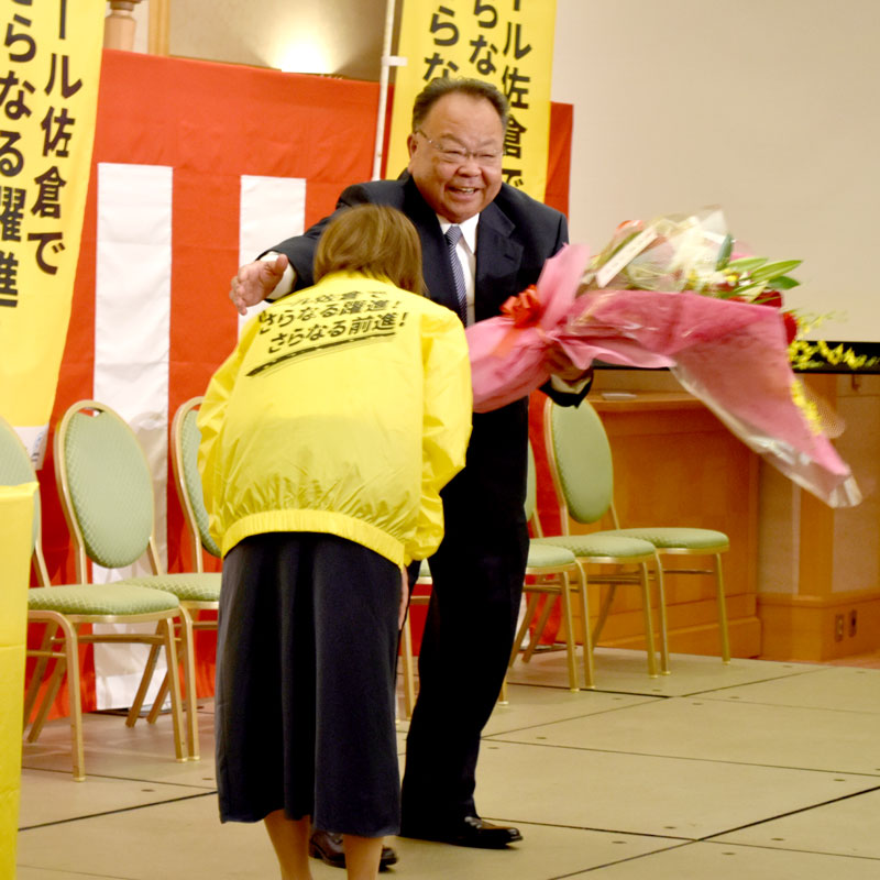 ２００票差を切る大接戦の末に再選を決め、花束を受け取り笑顔を見せる西田氏＝２３日午後１１時１５分ごろ、佐倉市