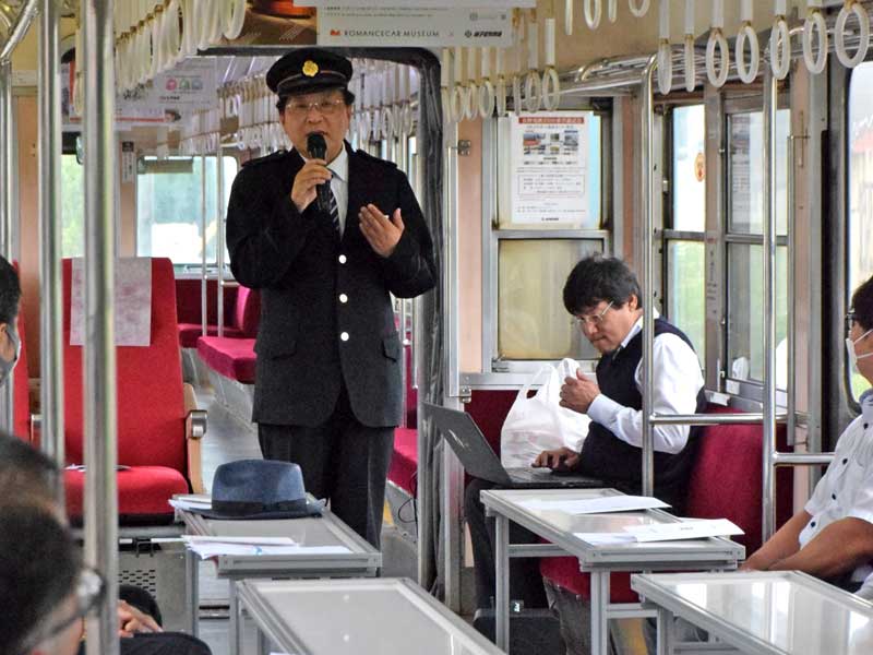 走行する列車内で開かれた株主総会であいさつする竹本勝紀社長＝３０日、銚子市