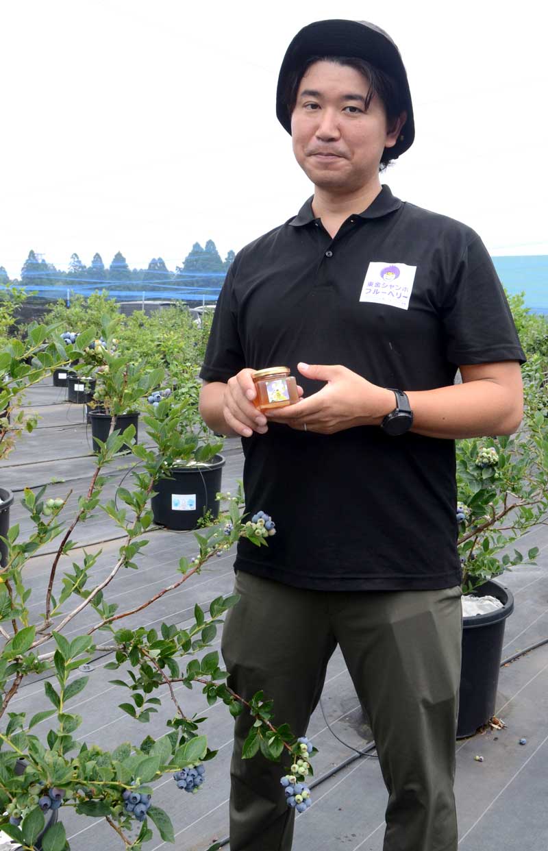 ブルーベリーの花から採取された蜂蜜を持つ宇井代表=東金市