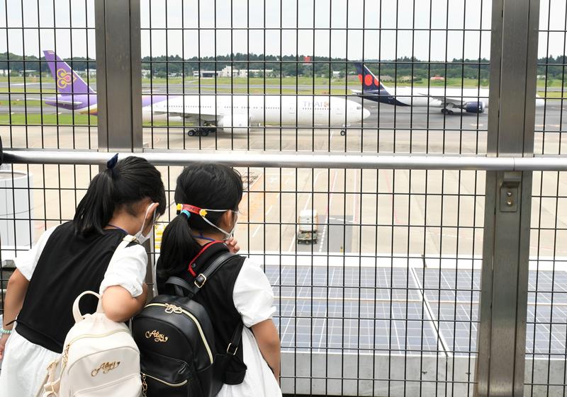 成田空港の展望デッキから滑走路を眺める子どもたち=24日、成田市