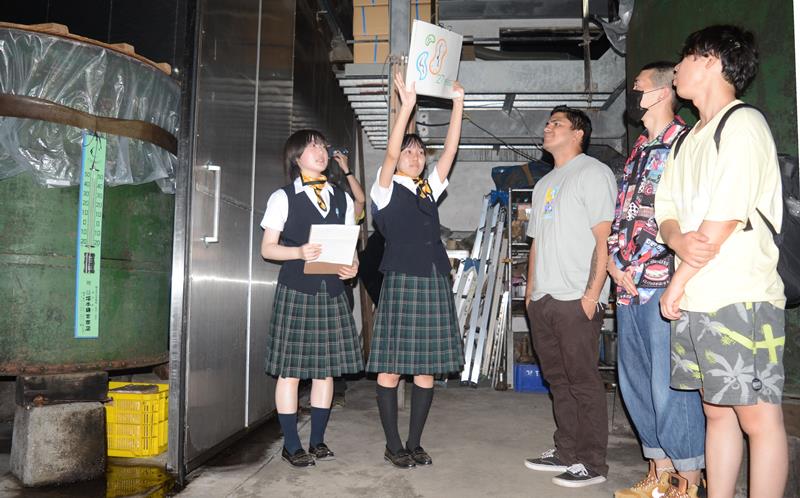 「守屋酒造」で留学生を案内する東金商業高の生徒ら(左から1、2人目)=17日、山武市