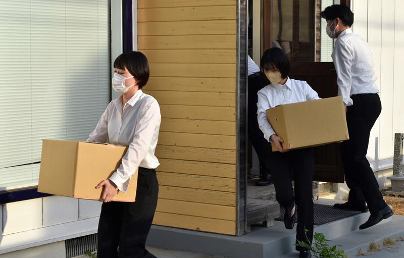 秋本衆院議員の地元事務所から、押収物が入っているとみられる段ボールを運び出す東京地検の係官ら＝４日午後５時２５分ごろ、佐倉市