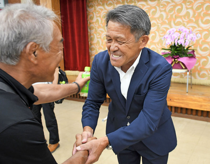 富里市長の再選を決め、支援者と握手して喜ぶ五十嵐氏(右)=6日夜、同市