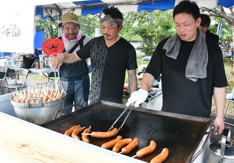 町特産の豚肉を使ったフランクフルトを焼く東庄町商工会青年部員=11日、同町