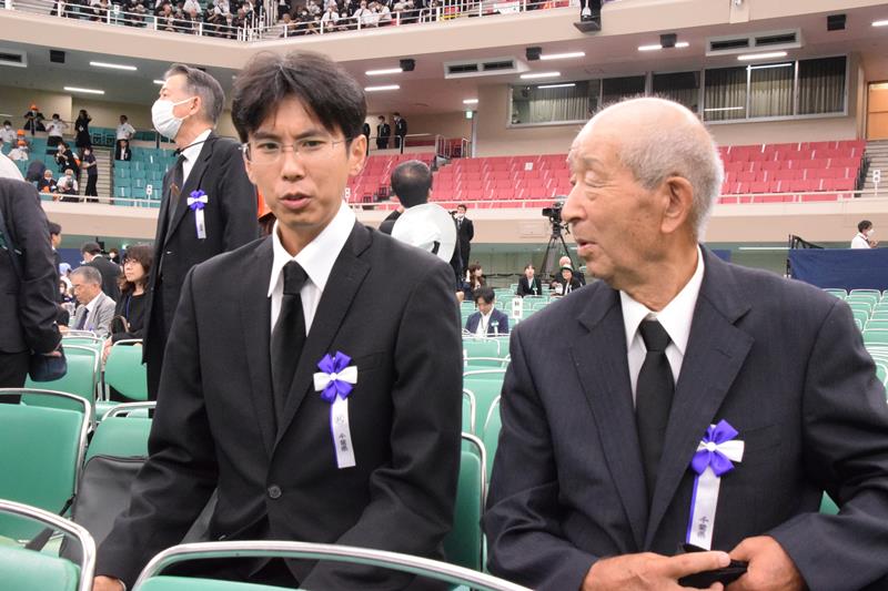 全国戦没者追悼式終了後に言葉を交わす県内最年少参列者の小川さん(左)と最年長の佐藤さん=15日、東京都千代田区の日本武道館