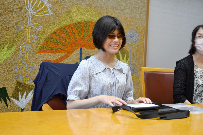 点字ディスプレーを使いドイツ語の発音を披露する小汐さん＝船橋市役所
