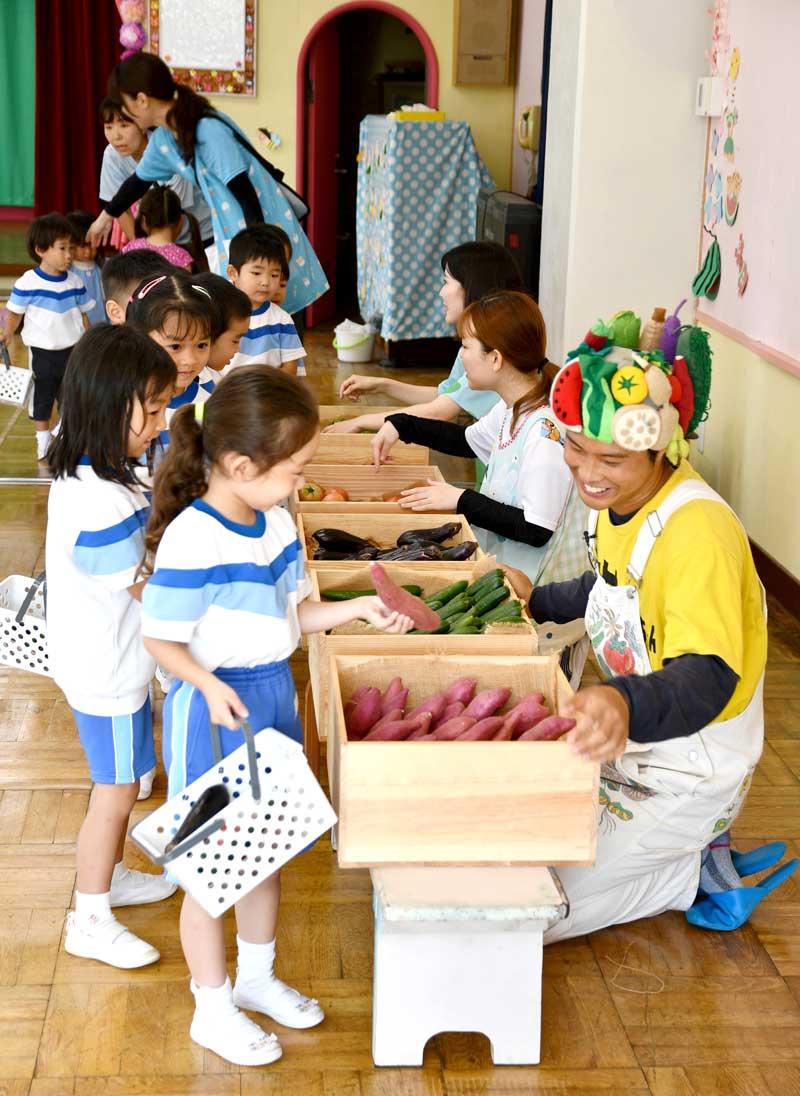 ヤサイちゃんがプレゼントとして持参した野菜を選ぶ園児ら=31日、横芝光町の 横芝まさご幼稚園