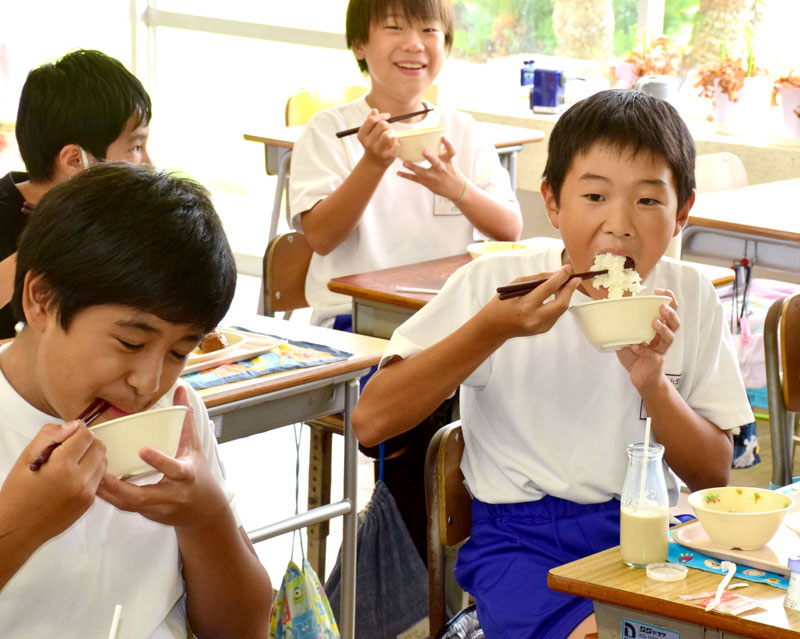 白子町産の新米を頬張る児童＝６日、同町立関小学校