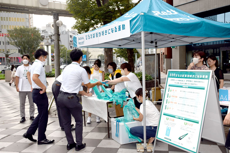 受付で、ごみ袋とトングを受け取る参加者=千葉市中央区