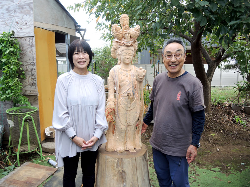 制作途中の十六面観音像を挟んで笑顔を見せる畠山さん（右）と石毛さん＝１０月２０日、流山市
