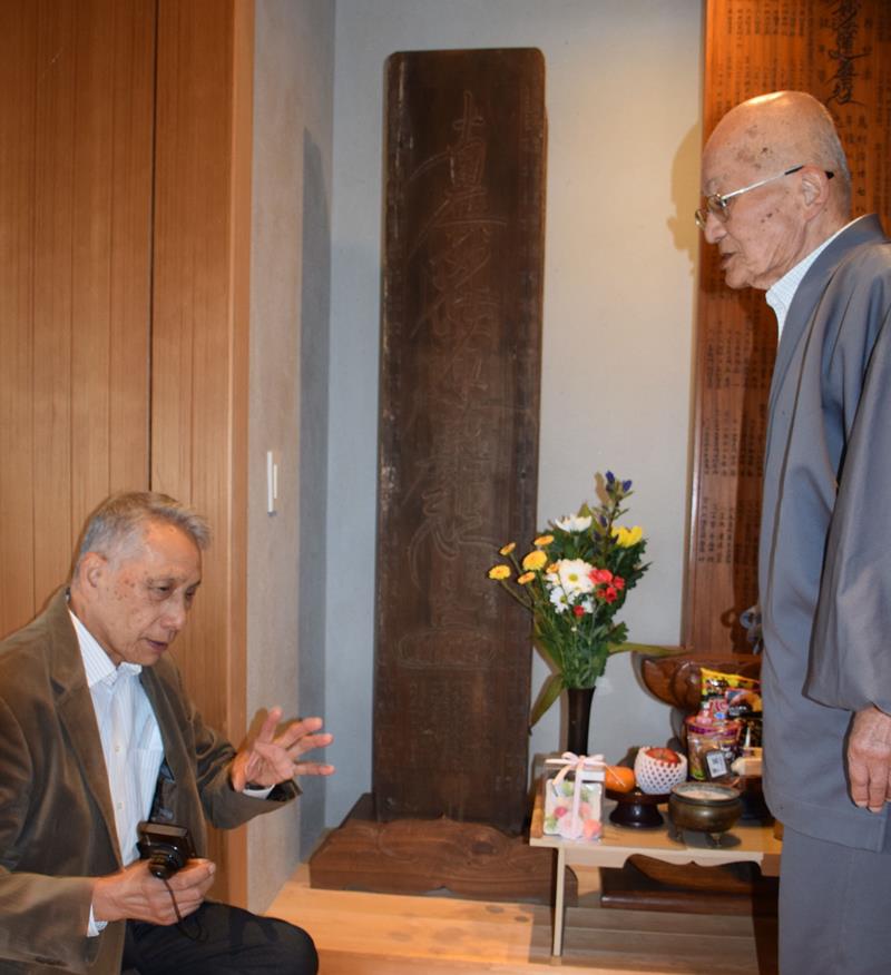 本興寺の大位牌を解説する古山豊さん(左)と平田日範住職=長生村
