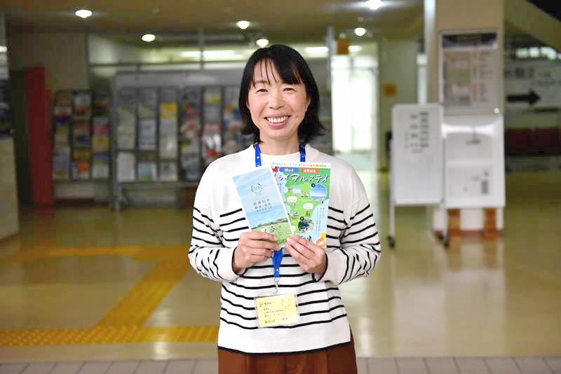 移住に関するパンフレットを紹介する長谷川さん=南房総市役所
