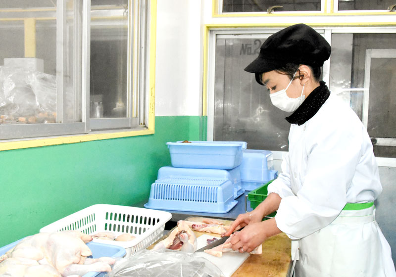 鶏肉をさばく孝子さん＝鴨川市