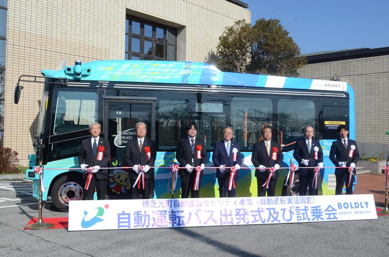 実証運行する自動運転バスの「出発式」で、テープカットに臨む佐藤町長（中央）ら＝１日、横芝光町