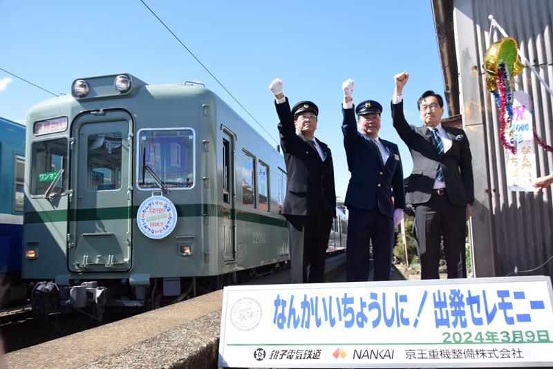 ホームに入った新車両と気勢を上げる竹本社長(左)ら=9日、銚子電鉄仲ノ町駅