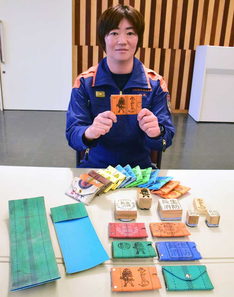 廃棄される消火用ホース(左下)で小銭入れを作っている新井さん。消しゴムスタンプ(中央)も手作りだ=長生村の長生分署