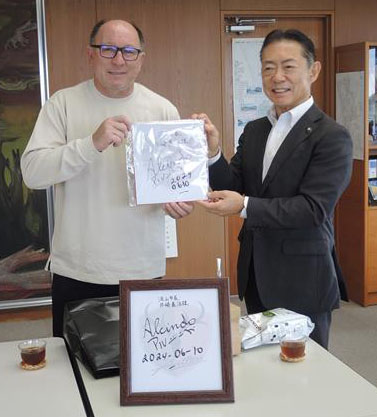 井崎市長(右)にサイン入り色紙を寄贈するアルシンドさん=流山市