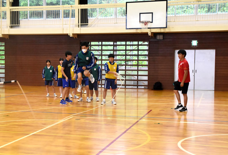 元五輪選手の野藤さん(右)から指導を受け、「8の字跳び」に挑戦する生徒