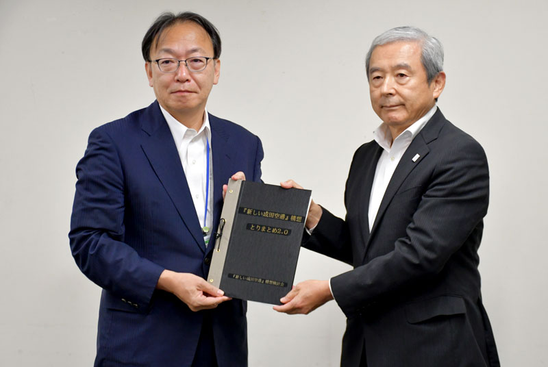 新ターミナル建設などを目指す「『新しい成田空港』構想」の報告書を平岡航空局長（左）に手渡すＮＡＡの田村社長＝３日、東京都千代田区の国交省