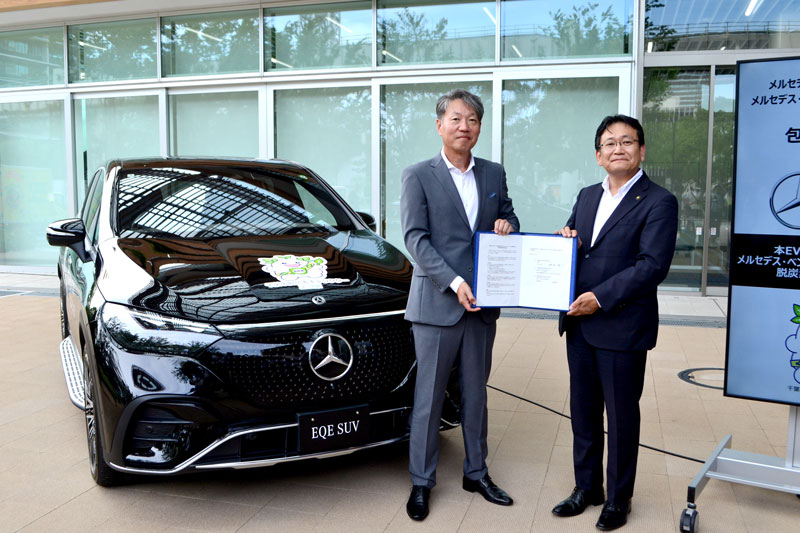 貸与する車両の前で協定書を掲げるメルセデス・ベンツ日本の上野社長と神谷市長＝２４日、千葉市役所