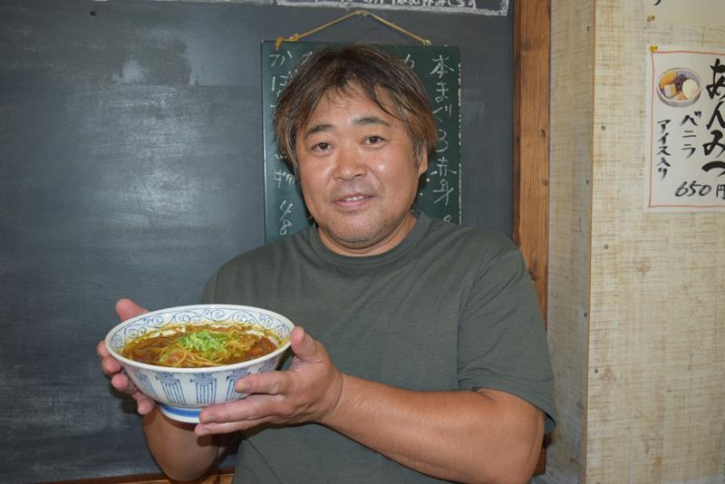 辛さと梨の甘さが絶妙にマッチした「カレータンタンメン」を手にする本田さん=八千代市
