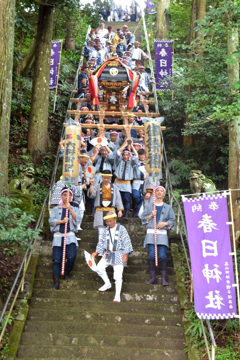 103段ある急勾配の石段をみこしを担いで降りる春日神社の氏子ら=28日、御宿町高山田