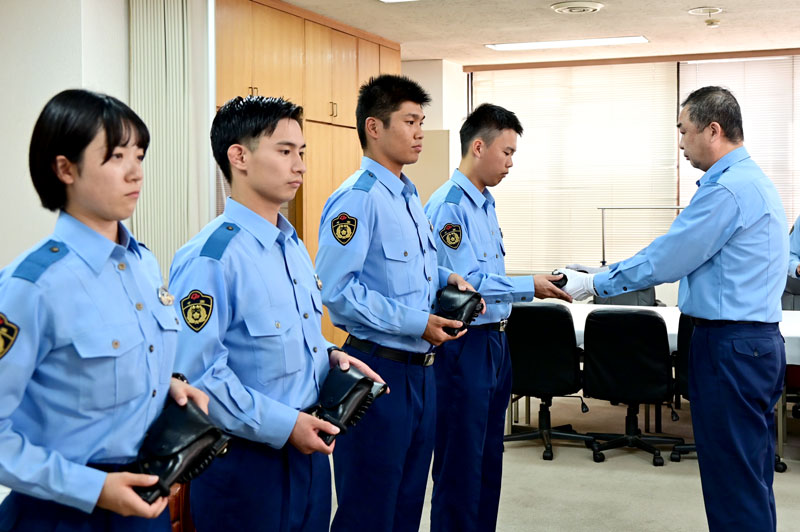署長から新人警察官4人に拳銃が手渡された=3日、八千代市の八千代署