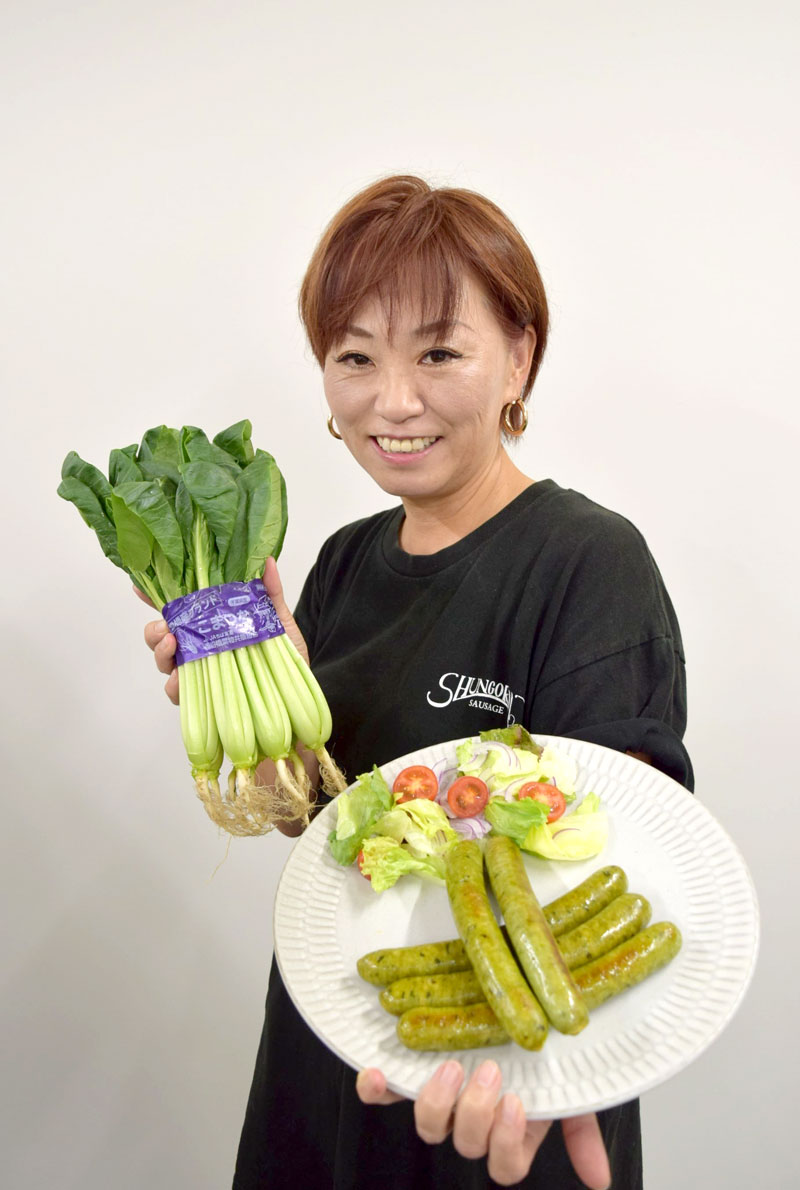 小松菜パウダー入りの「船橋ソーセージ(仮称)」をPRする渡辺社長=船橋市役所