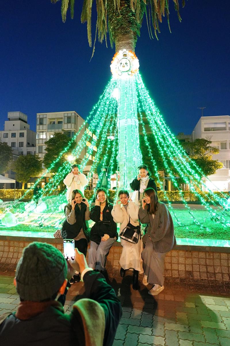 光輝くイルミと一緒に写真撮影する市民ら=銚子市