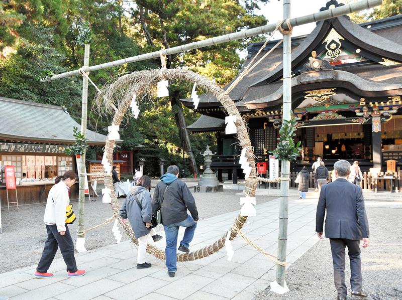 心身の汚れを清めるための「茅の輪」をくぐる参拝客ら＝１０日、香取市