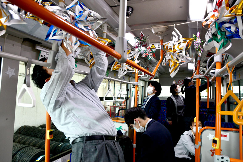 シャトルバスの車内をクリスマス仕様に装飾する多古高生=多古町