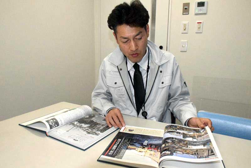 東日本大震災発生時に市の広報広聴班だった職員の石田さん。関わった広報誌や当時のメモ帳も開いて取材に応じてくれた=1月、旭市