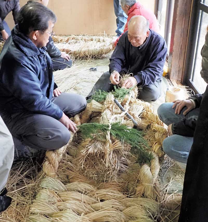 大わらじを作る住民たち。約2時間で完成した=2日、富津市