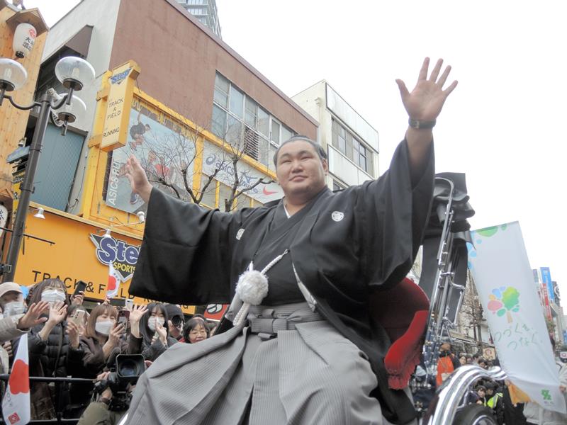 柏駅東口での祝賀パレードで祝福に手を上げ応える豊昇龍関=16日、柏市