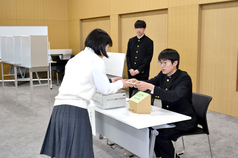 投票用紙を交付する作業を体験する生徒たち=千葉市役所