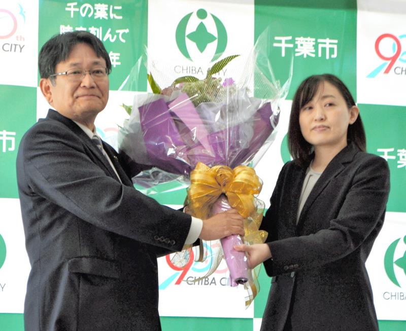 千葉市長選で再選を決め、市役所に登庁した神谷俊一市長（左）。職員から花束を受け取り、２期目に臨む決意を新たにした＝１７日、千葉市役所